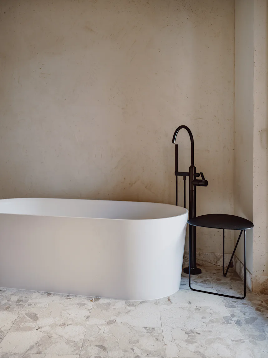Freistehende Wanne vor einer Kalkputzwand